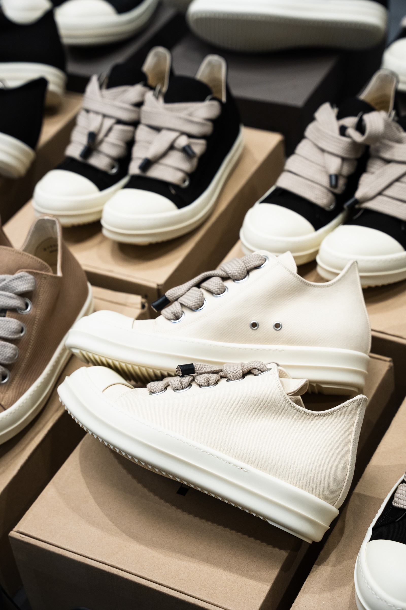 Close-up of cream and black sneakers with oversized laces.