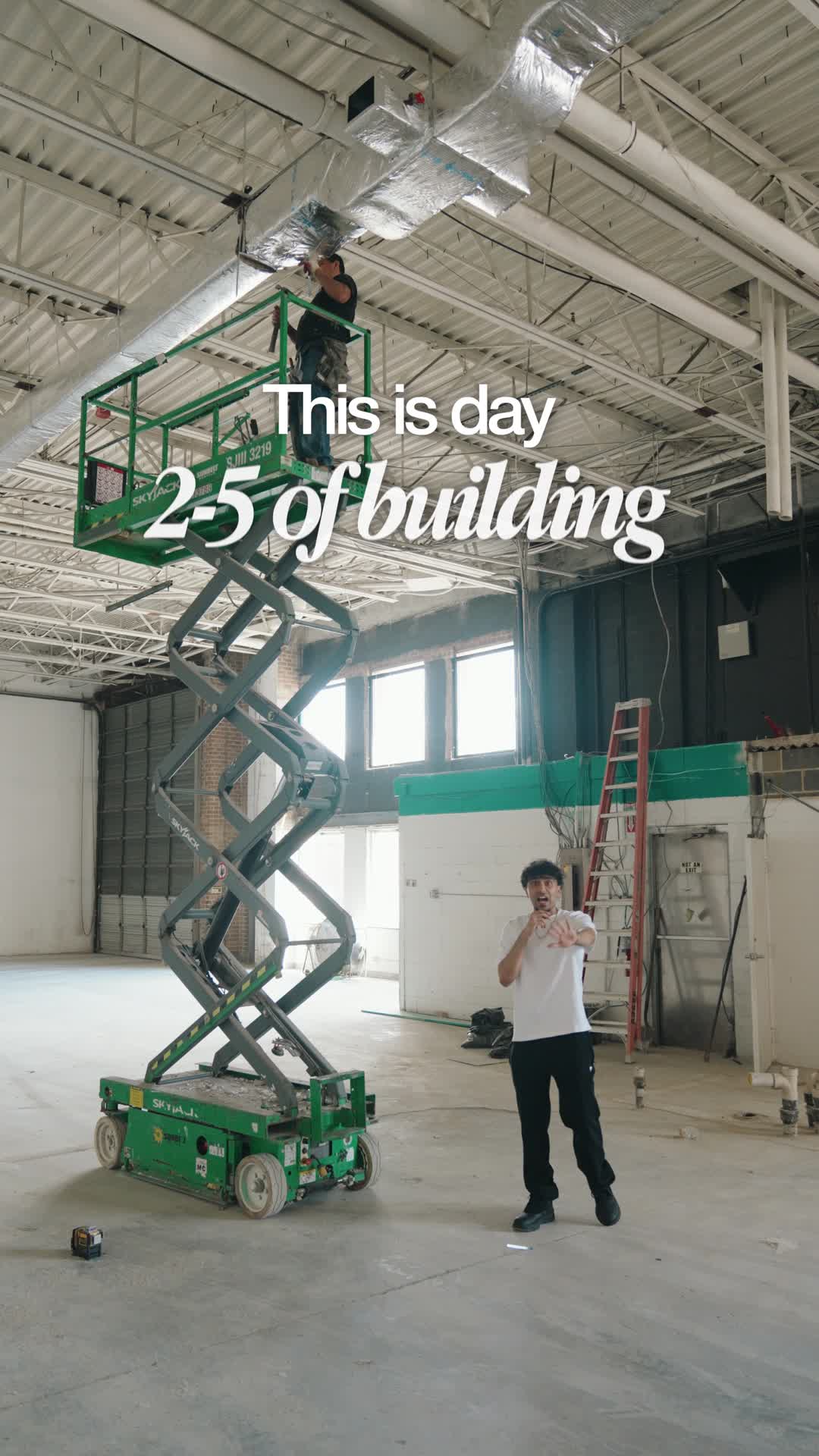 Jade beneath the new HVAC ductwork beside a green lift, with the opening title “This is day 25 of building.”