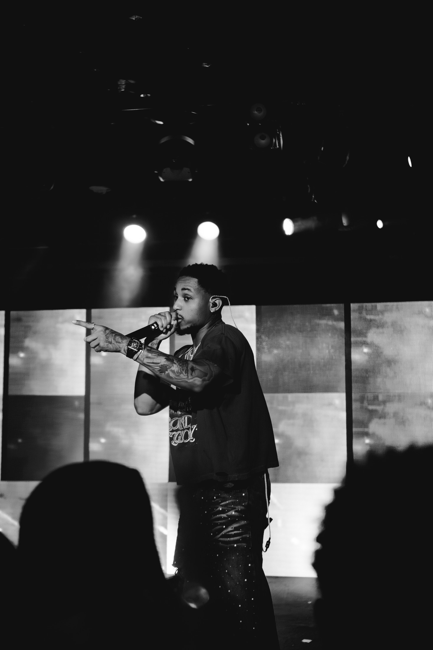 Black-and-white photograph of DDG pointing toward the crowd while performing into a microphone.